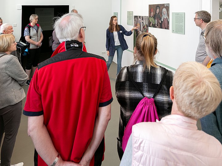 Eine Gruppe lässt sich Bilder an der Wand erklären