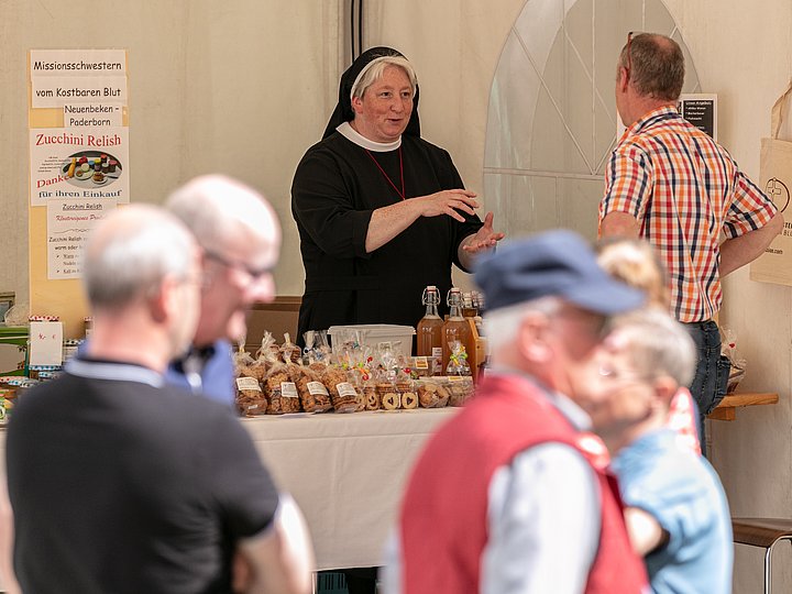 Eine Ordensschwester im Gespräch an einem Verkaufsstand