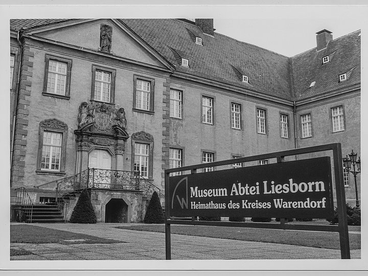 Historische Aufnahme des Abteigebäudes mit dem Schild „Museum Abtei Liesborn — Heimathaus des Kreises Warendorf“