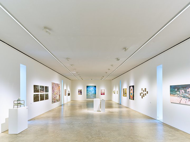 Langer heller Ausstellungsgang mit Fotografien an den Wänden