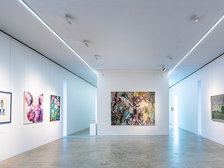 Moderner weißer Saal mit farbigen Gemälden