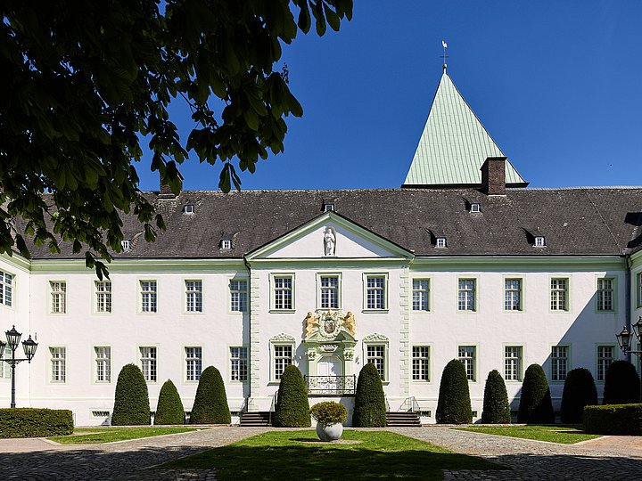 Die barocke Abtei Liesborn mit ihrem Vorplatz, dahinter der Turm der Abteikirche