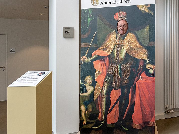 Ein Aufsteller mit dem Logo des Museums und einem Herrscherbildnis